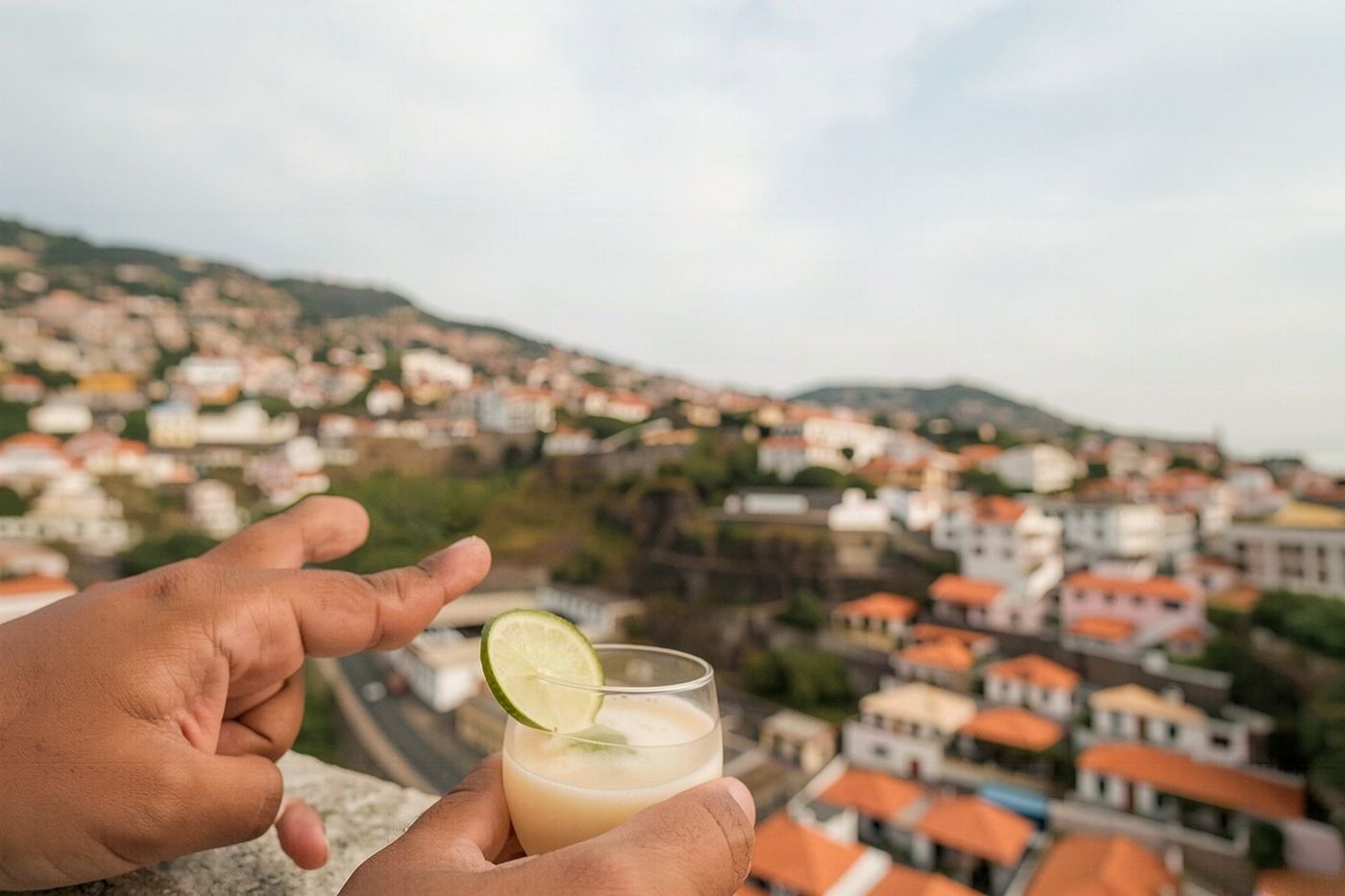 A small ceramic cup filled with amber liquid and garnished with lemon peel.
