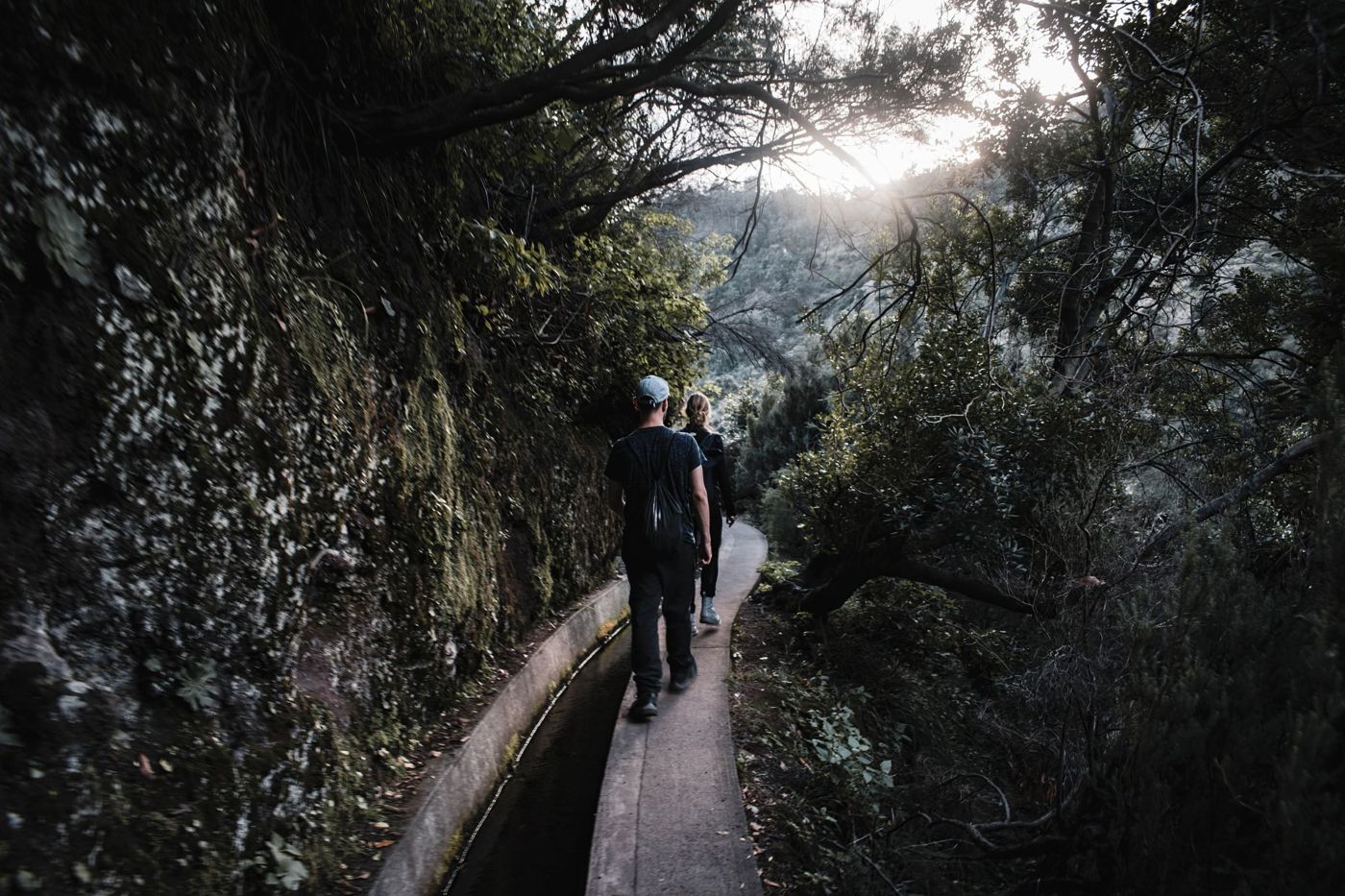 Een wandelaar op een levada-pad op Madeira, het waterkanaal naast het voetpad