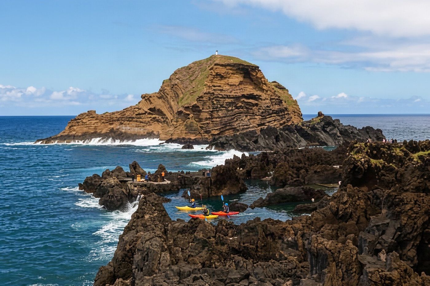 People engaging in water sports on the rugged coastline near the northern village of Porto Moniz.