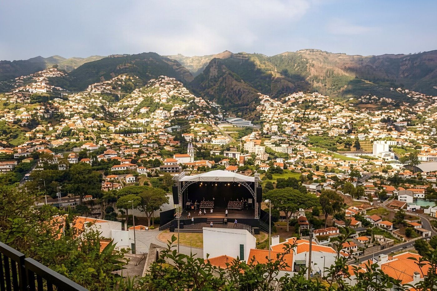 An outdoor concert stage surrounded by greenery in the central Funchal Municipal Garden.