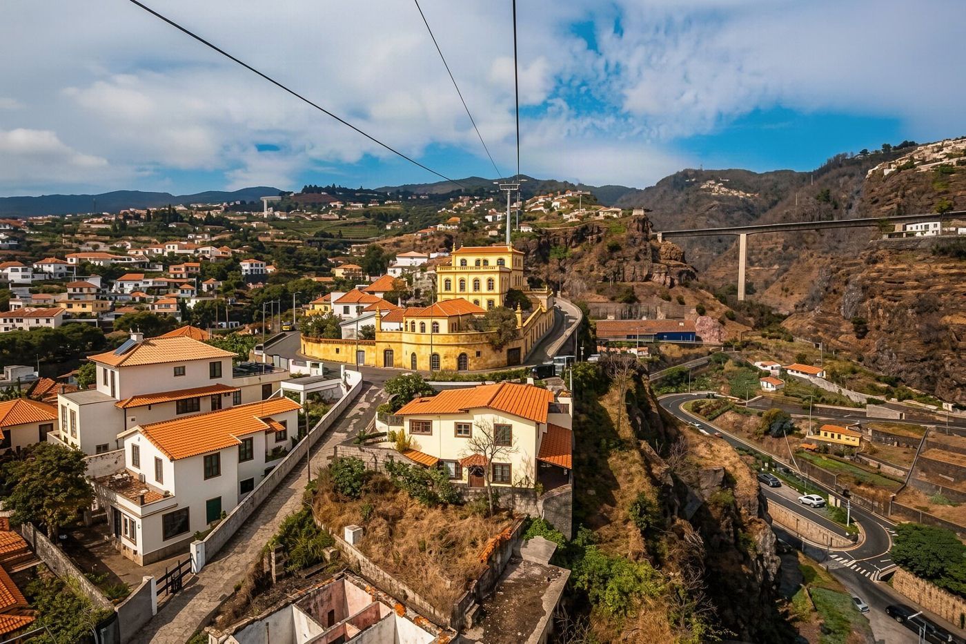 A historic yellow fort stands at the terminus of a street lined with colorful painted doors in Funchal.
