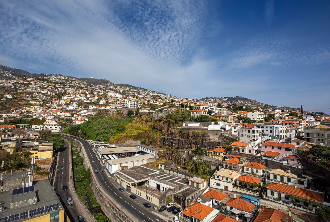A sunny walkway along the Funchal waterfront with clear blue skies typical of early autumn.