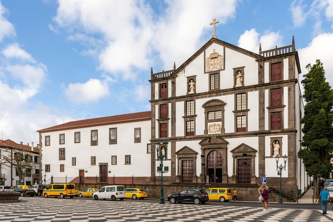A historic church facade facing a public square with municipal buildings.
