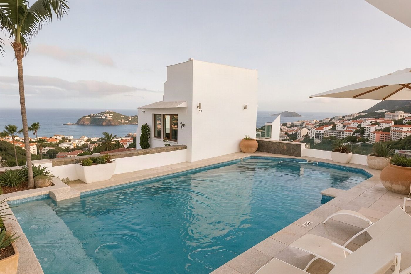 A hotel rooftop pool in Funchal offering panoramic views over the city and the Atlantic Ocean.
